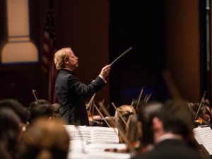 Symphony conductor on stage with orchestra